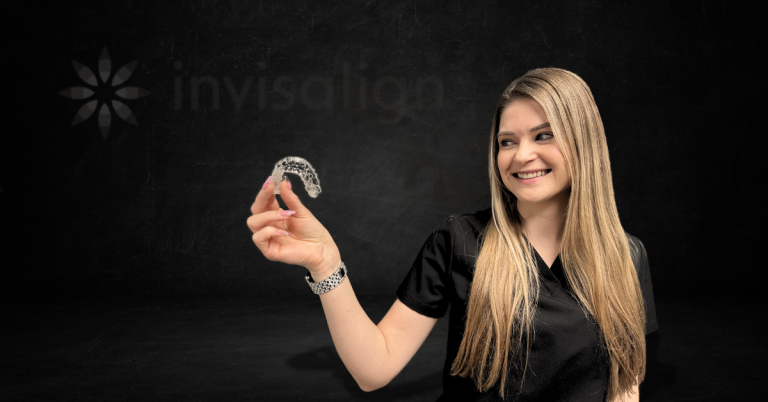 Restore Modern Dentistry team member holding clear Invisalign aligners with a warm smile inside the Bentonville, AR dental office.